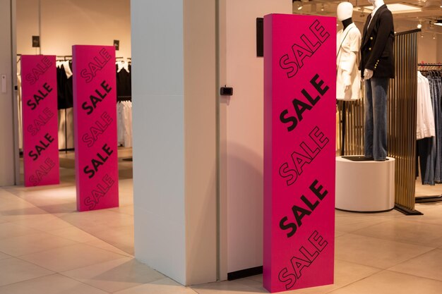 Foto porta antifurto viola brillante all'ingresso di un negozio di abbigliamento con un'iscrizione di vendita nera