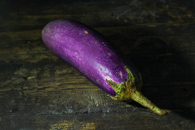 Bright Purple Fresh healthy eggplants on dark wooden background