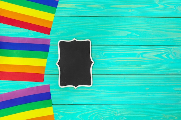 Bright rainbow gay flag on wooden background and blank space