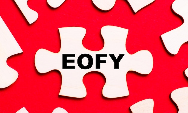 On a bright red background white puzzles In one of the pieces of the puzzle the text EOFY