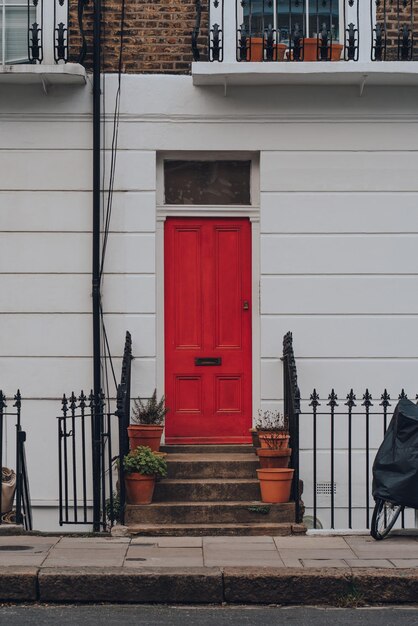 Bright red front door on a typical english terraced house in primrose hill london uk