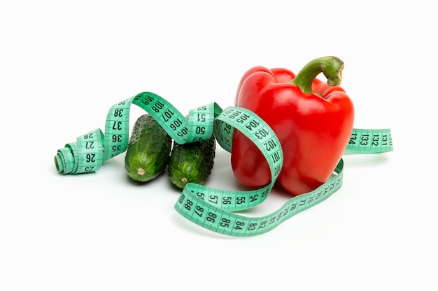 Bright red pepper and cucumbers with Measuring tape white