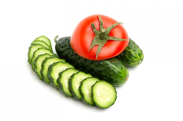 Bright red whole tomato and slices green cucumbers whole isolated on a white space