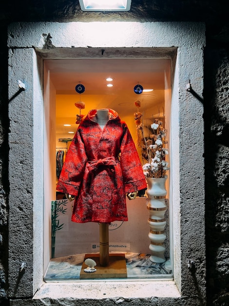 Foto il cappotto rosso brillante di una donna in una vetrina