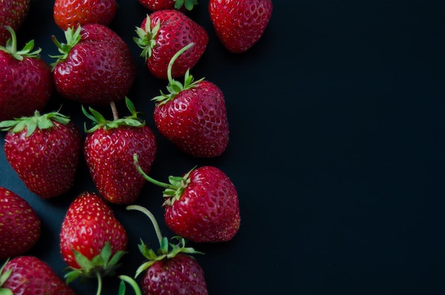Bright ripe strawberry on a black background closeup