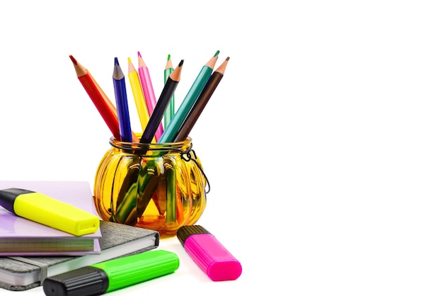 Foto set luminoso per cancelleria scolastica su sfondo bianco matite colorate penne vernici in plastica e p