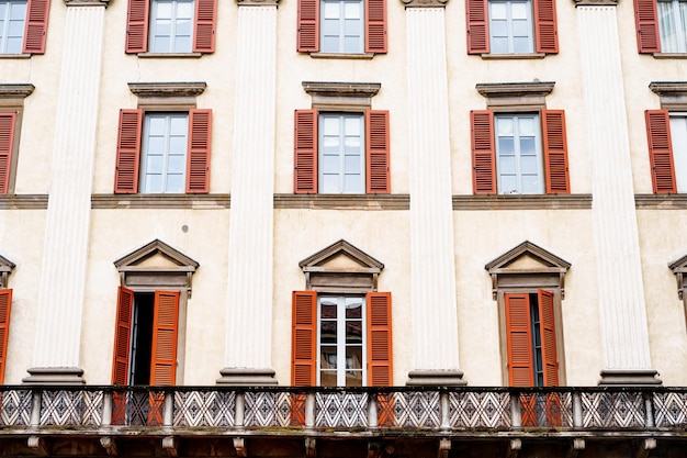 Bright shutters on the white windows of an old house with columns bergamo italy