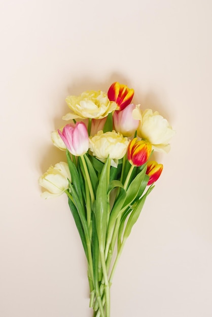 A bright spring bouquet of tulips on a beige background Flat lay greeting card