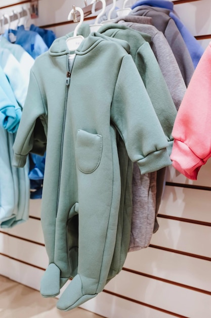 Bright spring jumpsuits for newborns hang on hangers in a children's clothing store