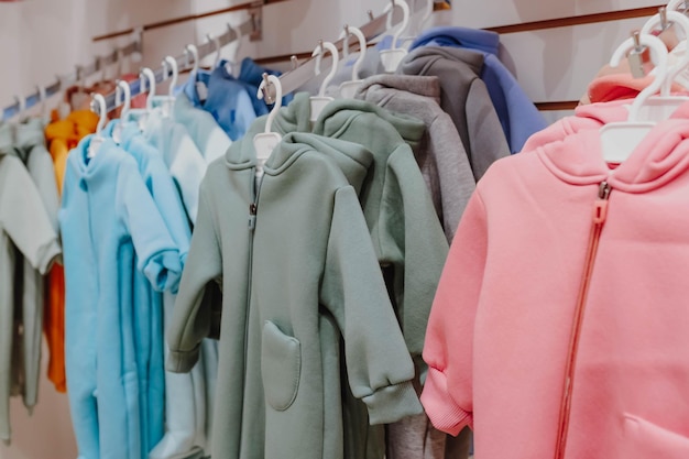 Bright spring jumpsuits for newborns hang on hangers in a children's clothing store