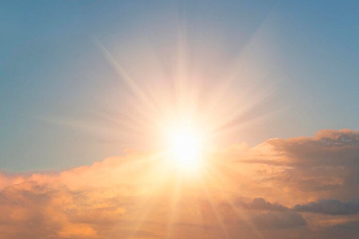 Photo bright sun in a blue sky with clouds background
