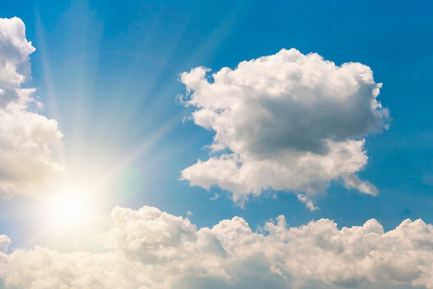 Bright sun on blue sky with white fluffy clouds background