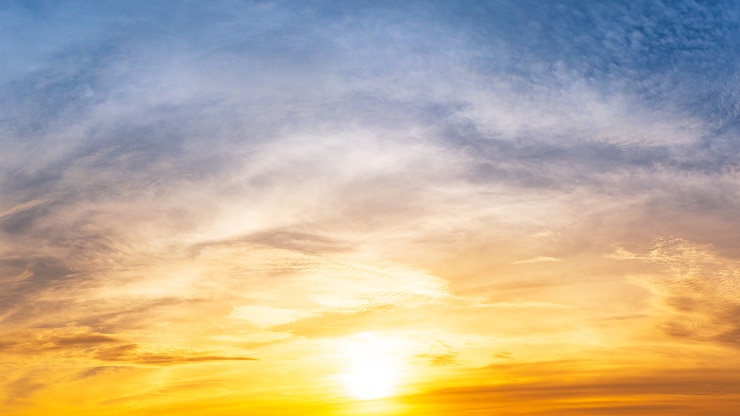 The bright sun was rising in the cloudy morning sky.