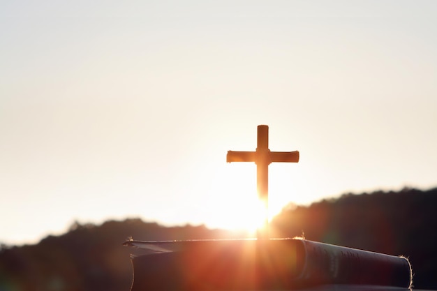 Bright sunlight, bible and holy jesus christ cross silhouette