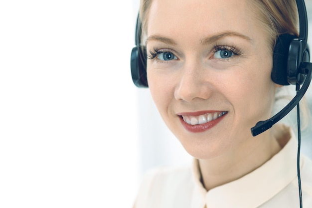 Bright and sunny call center. Group of blonde women in headset at work. Office and business concept.