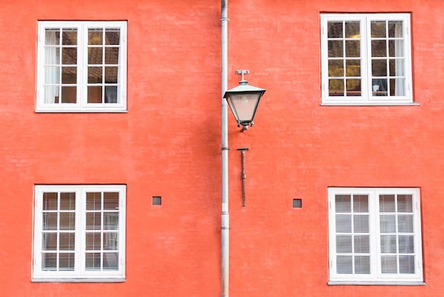 Bright terracotta wall street lantern and four windows