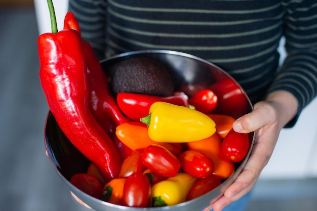 Bright vegetables in a metal bowl in your hands