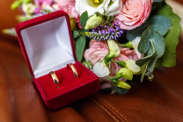 결혼 반지와 보라색 야생화와 여름 흰색 분홍색 장미와 난초의 밝은 웨딩 부케