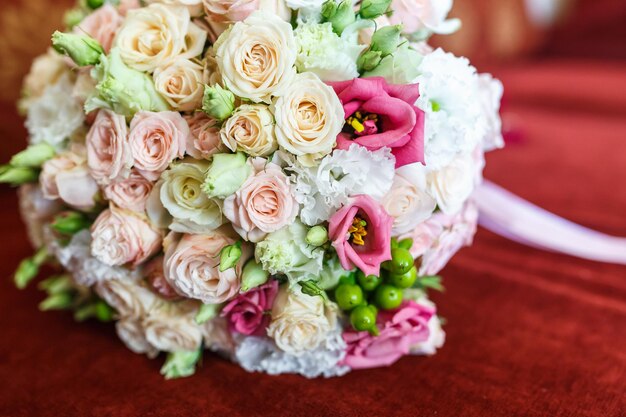 Bright wedding bouquet of summer white pink roses with wedding rings