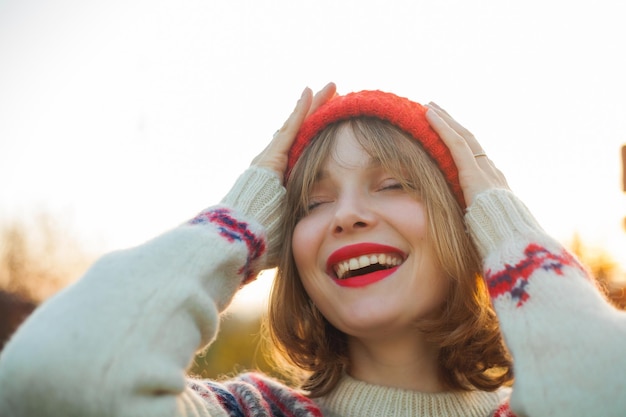 写真 クリスマス ツリー エコ クリスマス冬休日正月を背景にニットの赤い帽子の美しい若い女性の明るい冬の肖像画