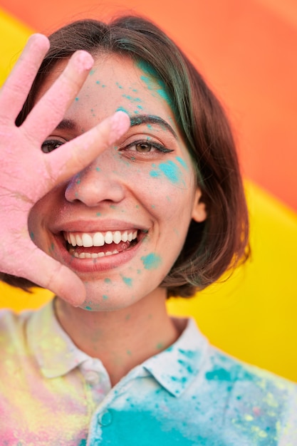 Bright woman in dry paints smiling at camera