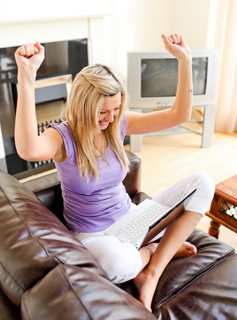 Bright woman sitting on sofa and working 