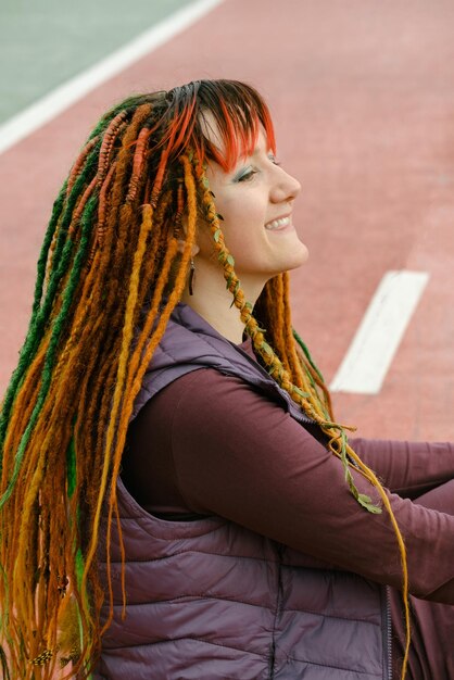 Photo bright woman with colorful braids on the road