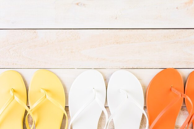 Bright women's flip flops on a wood board.