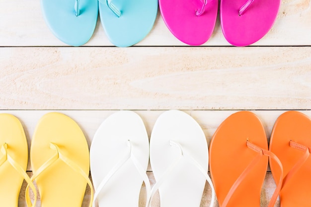 Photo bright women's flip flops on a wood board.