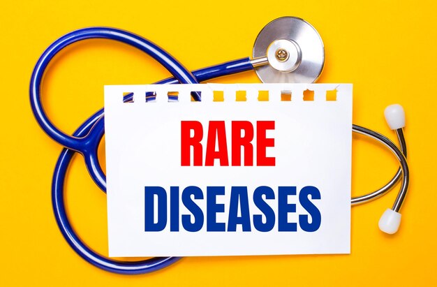 밝은 노란색 배경에 파란색 청진기와 RARE DISEASES라는 텍스트가 있는 종이 한 장. 의료 개념