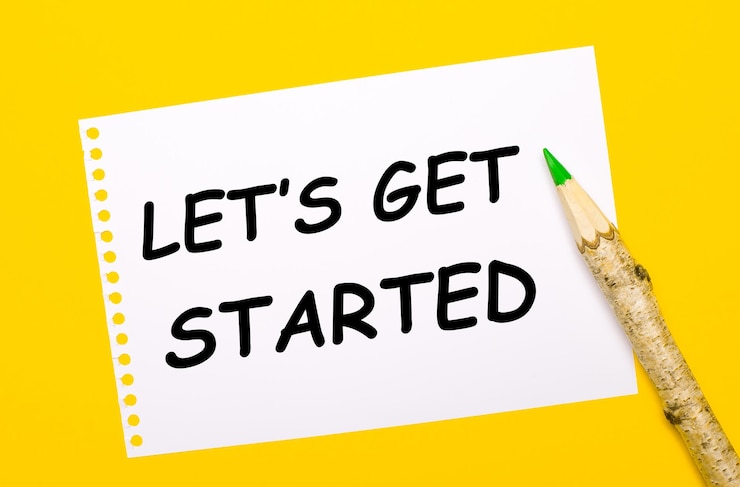 Photo 明るい黄色の背景に、大きな木製の鉛筆と「let isgetstarted」というテキストが書かれた白い紙