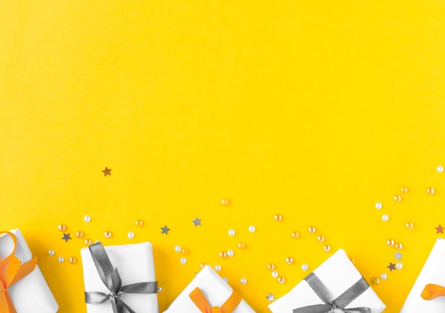 Bright yellow background with gifts and copy space