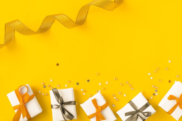 bright yellow background with golden and silver elements gifts and confetti