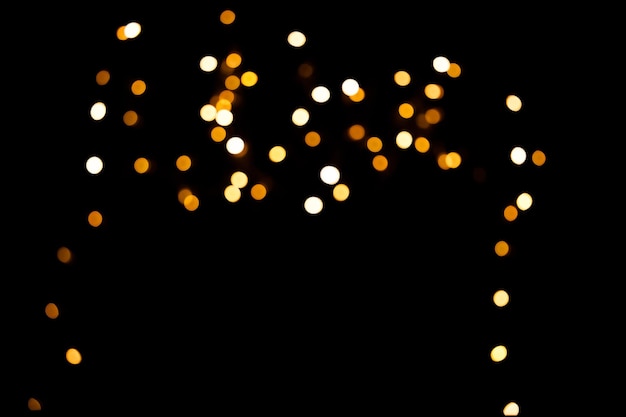 Bright yellow blurry lights on a black background. Bokeh for post-processing photos, design.