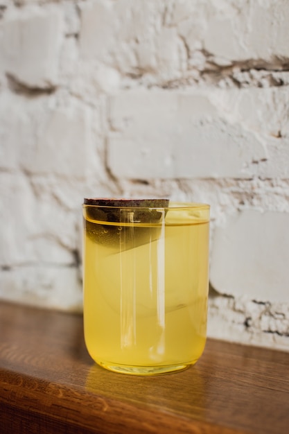 Ярко-желтый коктейль со льдом в низком бокале со льдом, украшенный маракуйей.