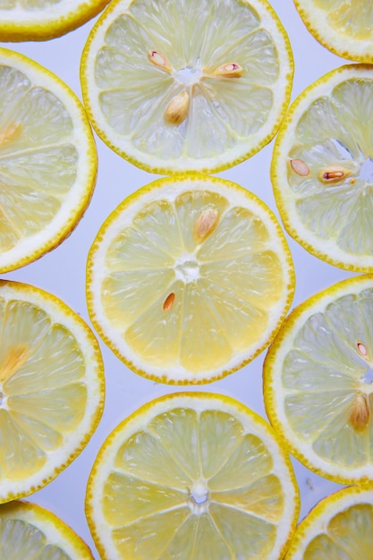 Ярко-желтые ломтики лимона с семенами на белом фоне