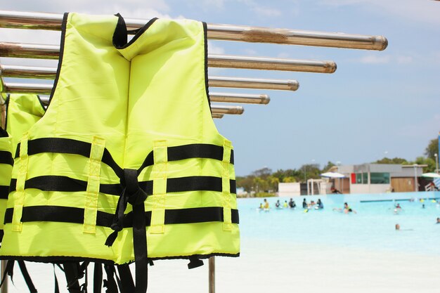 Bright yellow life jacket hangs next to the pool at the waterpark