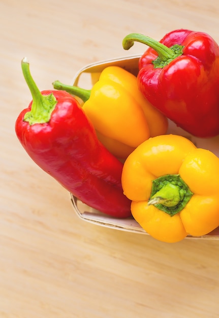 Bright yellow and red peppers closeup on the table