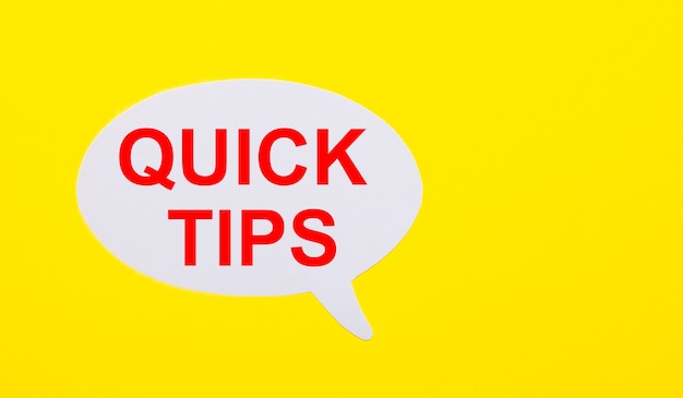 On a bright yellow surface, white paper with the words QUICK TIPS