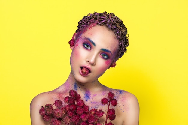 Photo bright young model posing with flowers