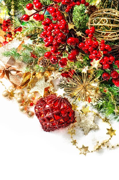 Brightly christmas decoration with red baubles, golden garlands, pine tree and berries branches. selective focus