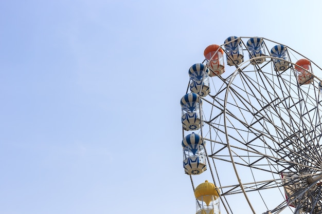 写真 青い空に対する明るい色の観覧車