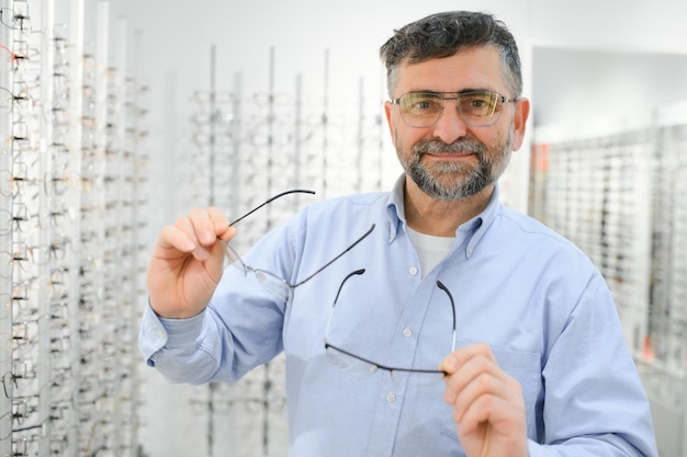 Bril controleren senior visie en oudere man in een consulterende optometriekliniek voor wellness Blije glimlach en oud gezicht met lensframe en brilkeuze in een winkel voor hulp bij het verkrijgen van een recept