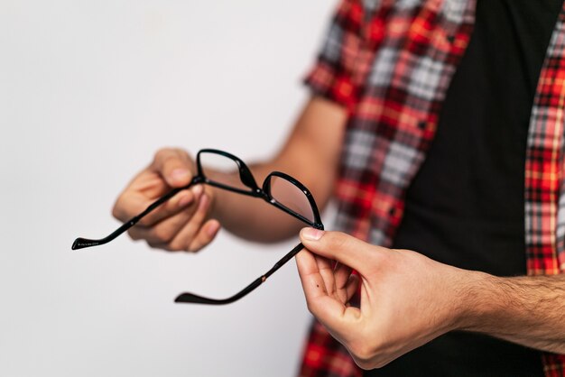 Bril in zwart frame in mans hand.