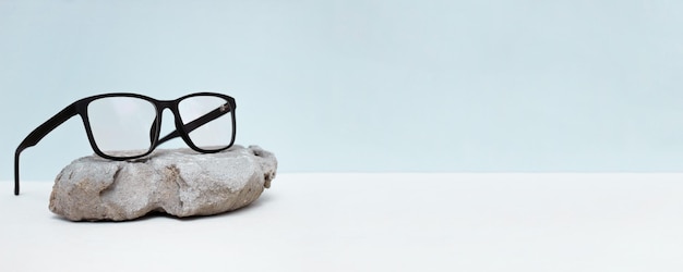 Bril op blauwe achtergrond met stenen bril verkoop concept kopie ruimte voor tekst optische winkelkorting