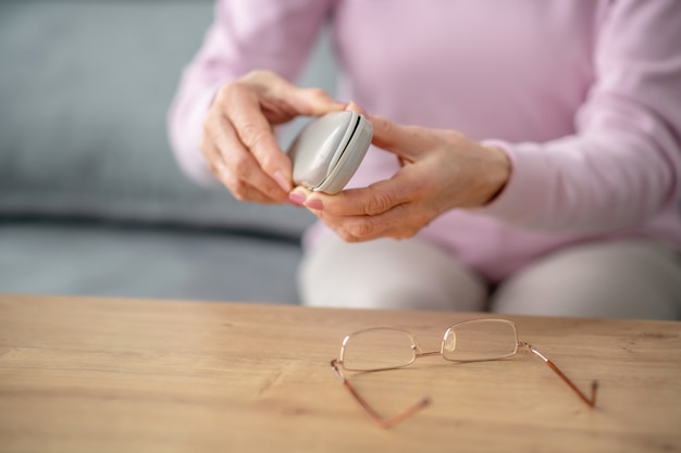 Bril. Senior vrouw met bril in haar handen