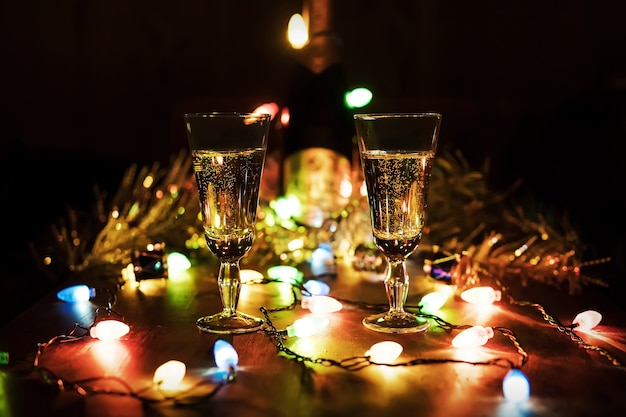 Bril tegen de achtergrond van een slinger. Champagne drinken in een romantische setting. De viering van Kerstmis en Nieuwjaar samen.