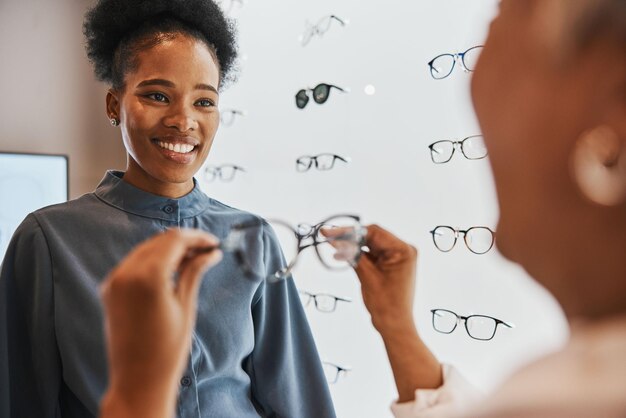 Bril, zwarte vrouw en winkelklant met winkelmedewerker en opticien die naar de lens kijken