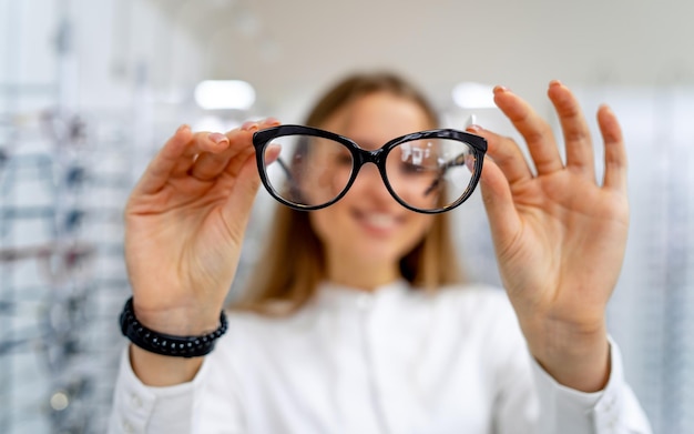 Foto brillen close-up bril in handen van de vrouw bril presenteren inzoomen