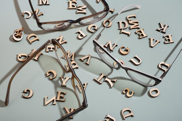 Brillen op pastelgroene achtergrond met houten letters Vision testoptical store concept